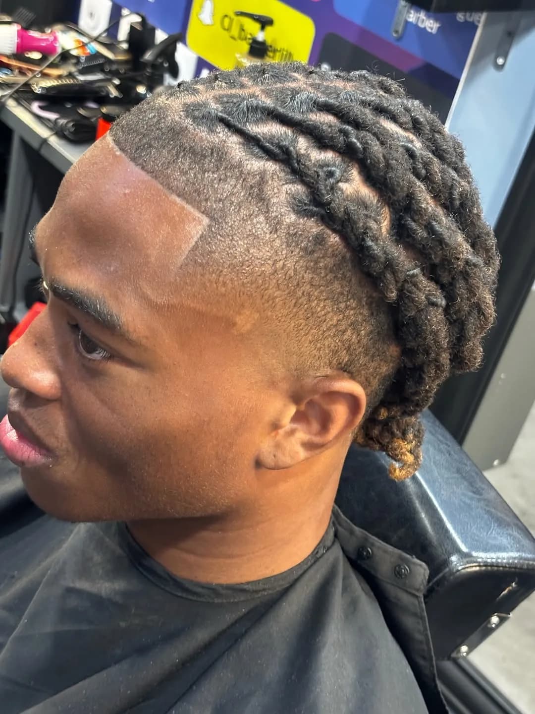 Locks retenus et contour du front tracé au rasoir chez Champions Barber